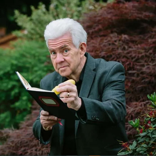 Ian McMillan holding a book